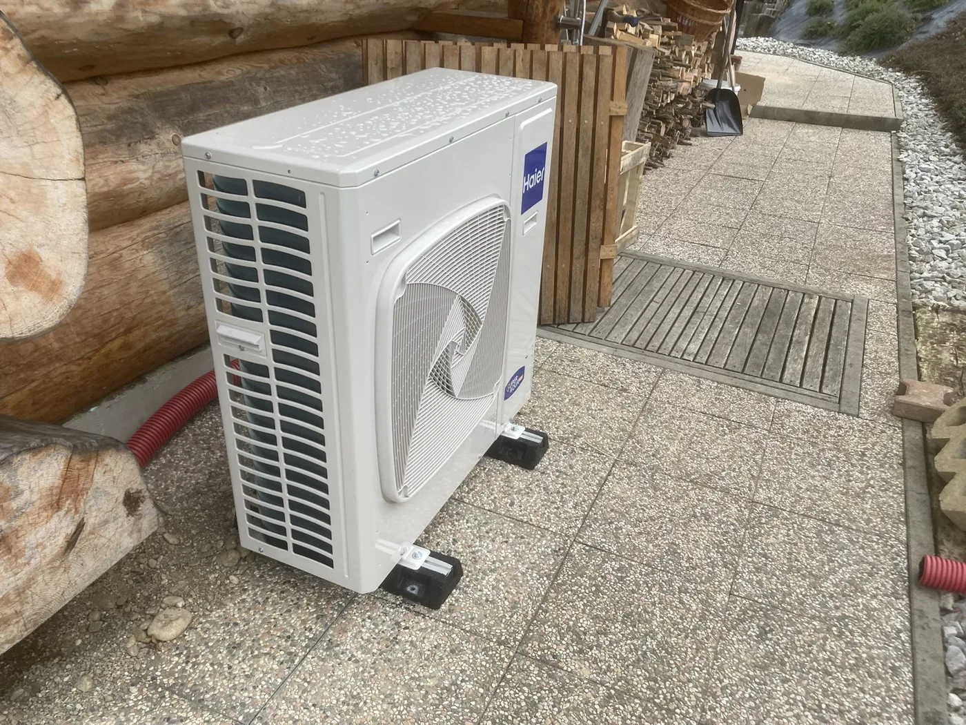 Zunanja enota klimatske naprave na podstavku ob objektu